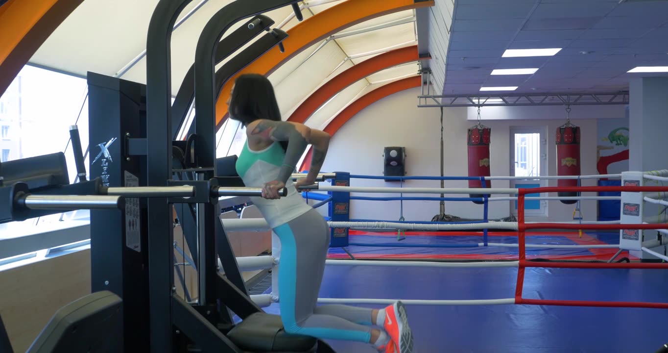 漂亮性感的女运动员在健身房做双杠俯卧撑。运动员视频下载