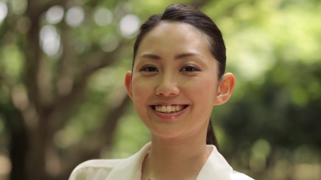 一个迷人的年轻日本女人在城市公园的肖像视频素材