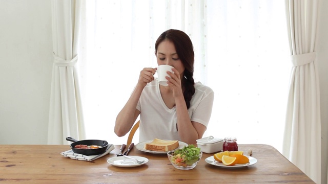迷人的日本年轻女子在家吃早餐视频素材