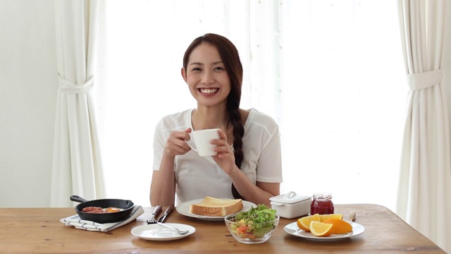 迷人的日本年轻女子在家吃早餐视频素材