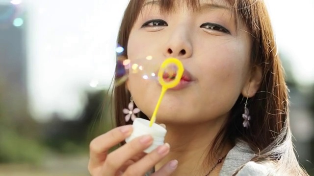 迷人的年轻日本女孩肖像吹肥皂泡视频素材