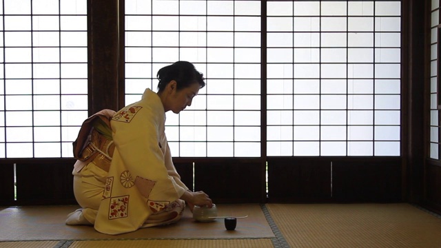 在传统的房子里，穿着和服准备绿茶的成熟日本妇女视频下载