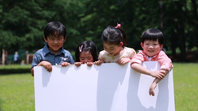在日本东京的一个公园里，日本的孩子们拿着白板视频素材
