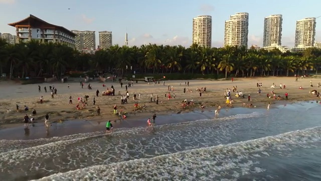 航拍文昌高隆湾夕阳下玩耍的人群视频素材