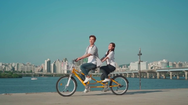 这对年轻夫妇在公园里骑自行车视频素材