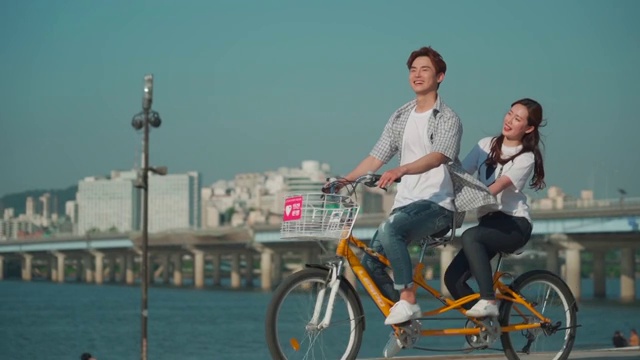 这对年轻夫妇在公园里骑自行车视频素材