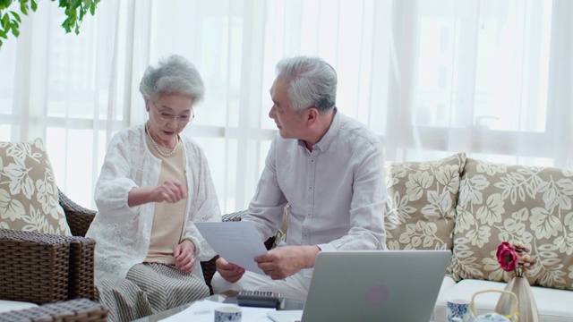 快乐的老年夫妇在客厅讨论理财视频下载