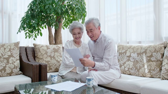 快乐的老年夫妇在客厅讨论理财视频下载