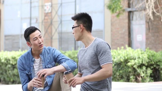 年轻男士在户外喝咖啡聊天视频素材