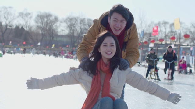 年轻情侣在冰上玩耍视频下载