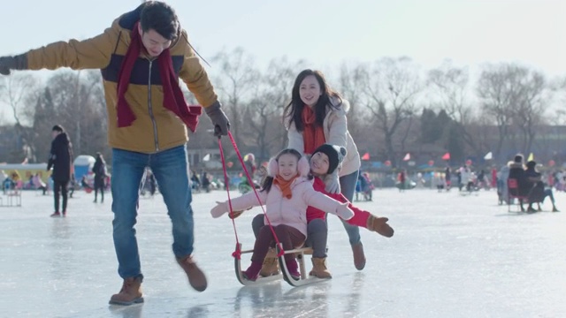 年轻家庭在冰上玩耍视频购买