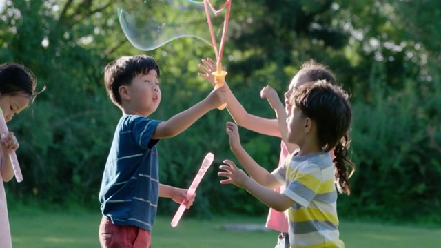 快乐儿童在草坪上吹泡泡视频购买