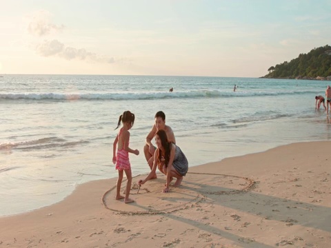 快乐的年轻家庭在沙滩玩耍视频下载