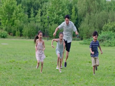 快乐年轻家庭在草地上玩耍视频下载