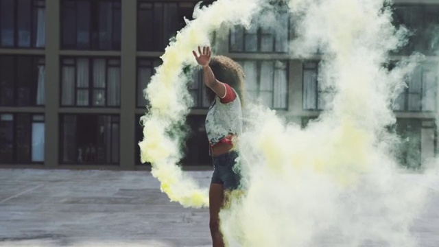 时尚的年轻女子在城市的屋顶上使用烟雾弹视频下载