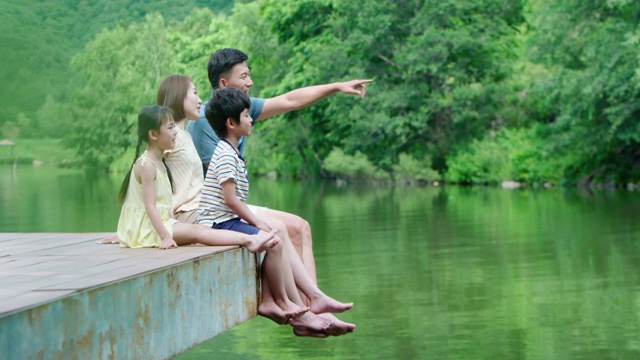 快乐的年轻家庭在河边玩耍视频下载