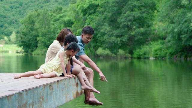 快乐的年轻家庭在河边玩耍视频素材