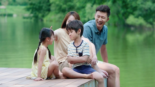 快乐的年轻家庭在河边玩耍视频素材