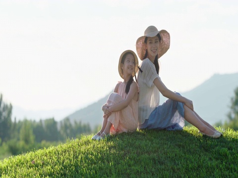 快乐的母女俩坐在草地上视频素材