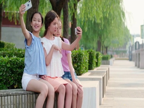青少年在公园使用手机自拍视频素材