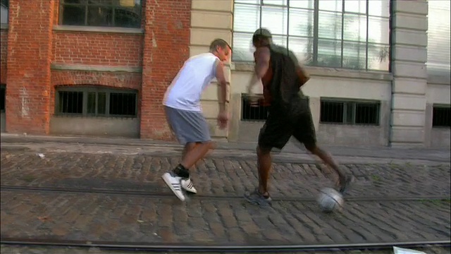 在纽约布鲁克林的城市街道/小飞象上，低角度跟踪中射手带球过了对手视频下载