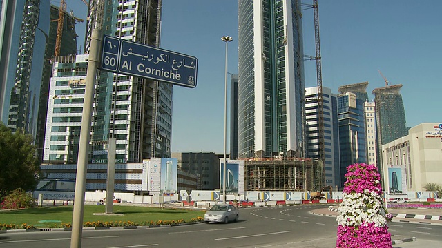 卡塔尔多哈金融区摩天大楼和街道上交通的WS TD街道名称标志视频下载