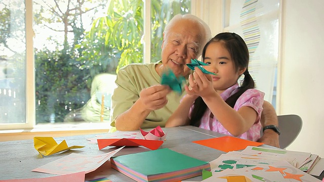 爷爷和孙女(8-9岁)玩折纸鸟/洛杉矶，加利福尼亚，美国视频下载