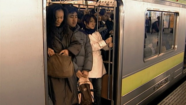 日本东京，上下班高峰期，乘客登上拥挤的地铁，在新宿站站台停下来/地铁关闭和列车离开站的门视频素材