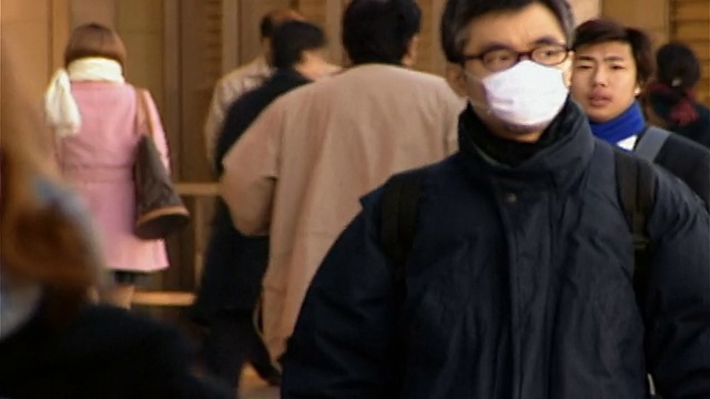 上下班高峰期穿过新宿车站的通勤者/戴口罩以防止疾病传播的人/日本东京视频素材