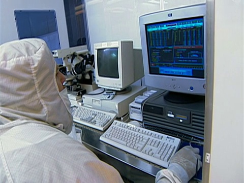 实验室技术员穿着无尘室套装在硅盘存储实验室的电脑前工作/纽约视频素材