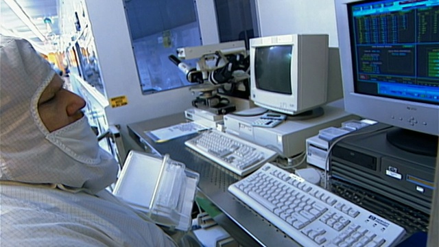 实验室技术员穿着无尘室套装在硅盘存储实验室的电脑前工作/纽约视频素材