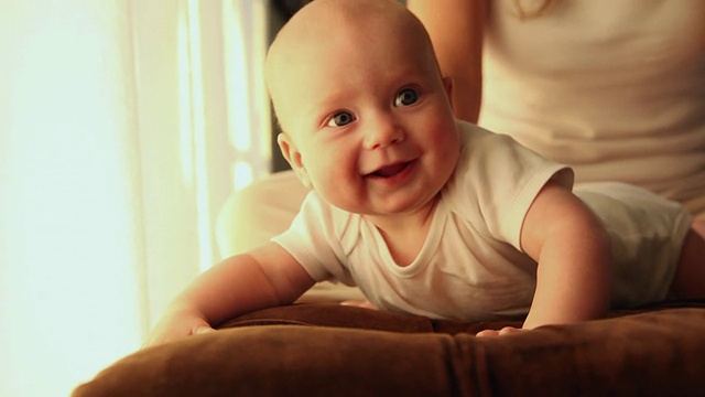 沙发上的婴儿扬起眉毛微笑/美国加州洛杉矶视频下载