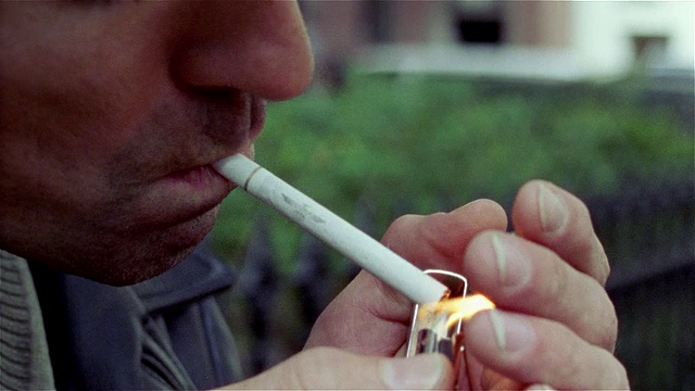 男子用Zippo打火机点燃香烟的特写视频下载
