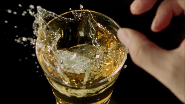 高速俯瞰冰块被扔进威士忌酒杯视频下载