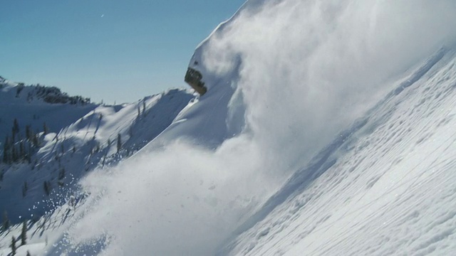 WS TS SLO MO Man滑雪在大岩石上与背光和细丝雪/阿尔塔，雪鸟，美国犹他州视频素材
