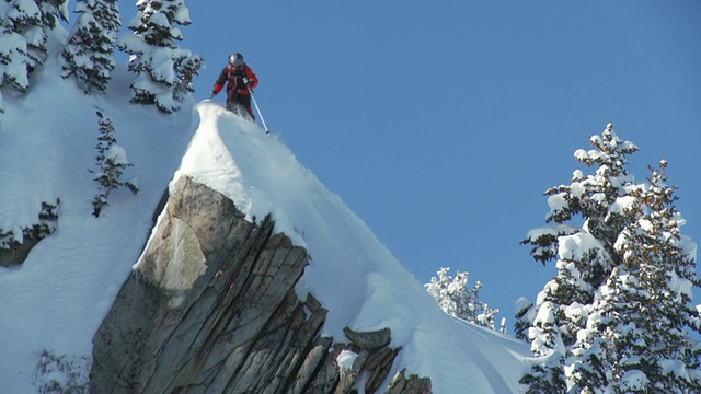WS TS ZO SLO MO Man跳跃和滑雪在大岩石上/阿尔塔，雪鸟，美国犹他州视频素材
