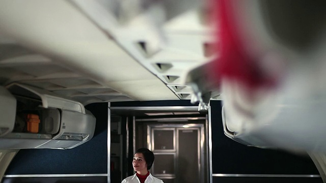 飞机上的空姐正在关闭头顶上的储物柜视频下载