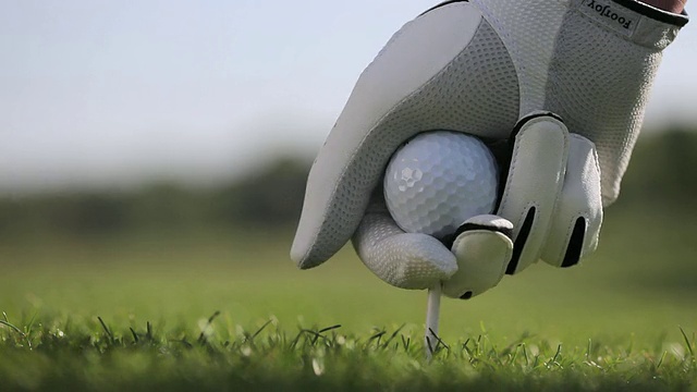 将高尔夫球放在球座上击球的人/坎特伯雷，肯特，英国视频下载