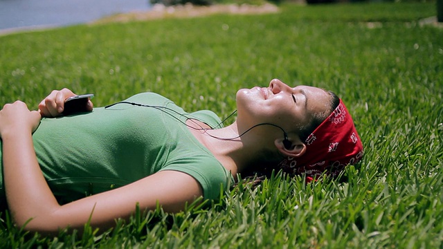 MS Girl(14-15)躺在草地上听音乐/ Cape Coral，佛罗里达，美国视频素材