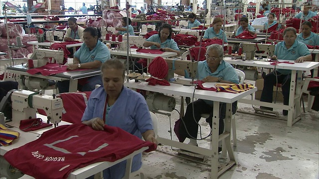在委内瑞拉Zulia Cabimas的缝纫厂，一名妇女正在检查成衣，站在工人旁边视频下载