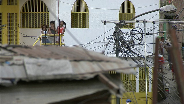 委内瑞拉，米兰达，加拉加斯，前景中的彼得雷贫民窟，三个女孩站在栏杆旁视频素材