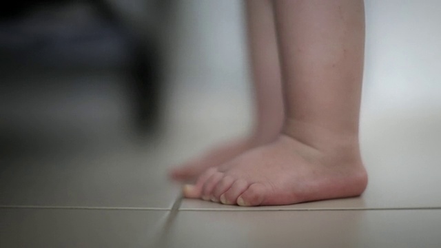 CU女婴(18-23个月)的脚在地板上，然后走出画面/圣玛丽，安提瓜，安提瓜和巴布达视频素材
