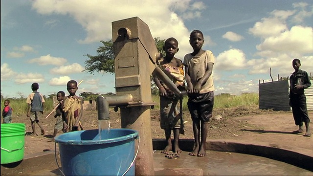两名儿童在手泵上给水桶注水/莫桑比克视频下载