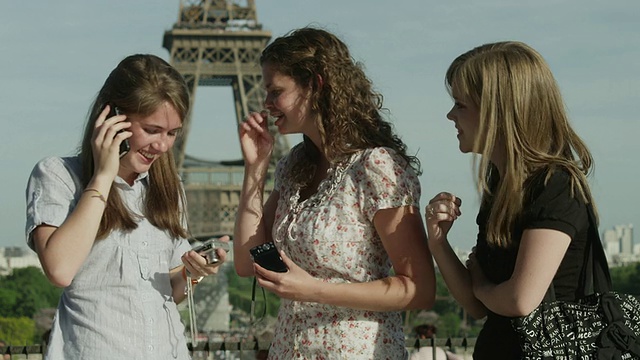 三个年轻女子站在埃菲尔铁塔前(法国巴黎)视频素材