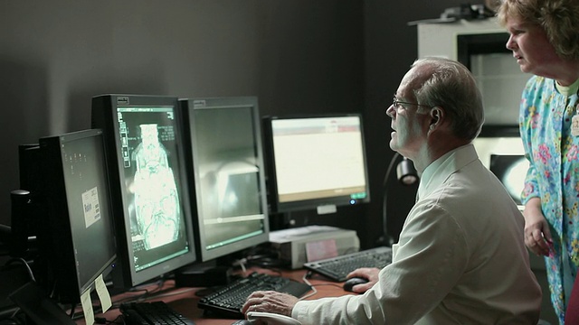 护士协助医生在PACS显示器(图像存档和通信系统)显示器上查看病人的扫描结果/美国缅因州波特兰视频下载