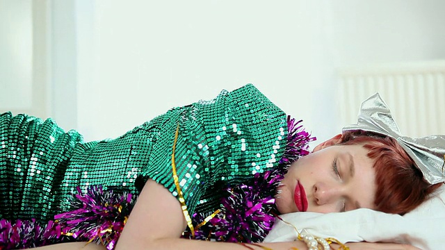 身着派对礼服的女士倒在床上/英国伦敦视频素材
