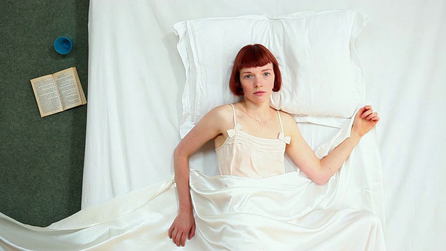 英国伦敦，女人在被单被拿走的床上醒来视频素材