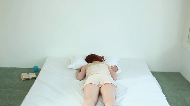 MS TD Woman falling onto bed /伦敦，英国视频素材