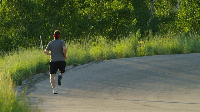 涂女士戴着假肢在美国犹他州的美国福克峡谷乡村公路上慢跑视频下载