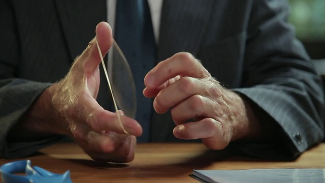 美国俄勒冈州波特兰市，一名男子在桌前用手拉橡皮筋视频下载